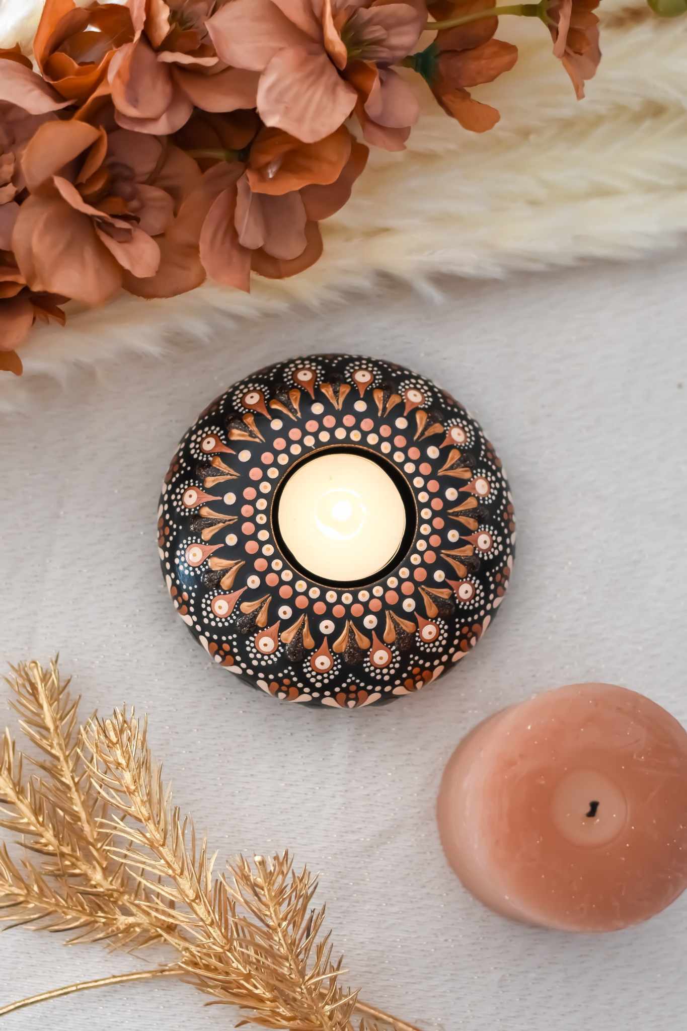 bougeoir fait main avec mandala rose et doré sur fond noir contenant une bougie.