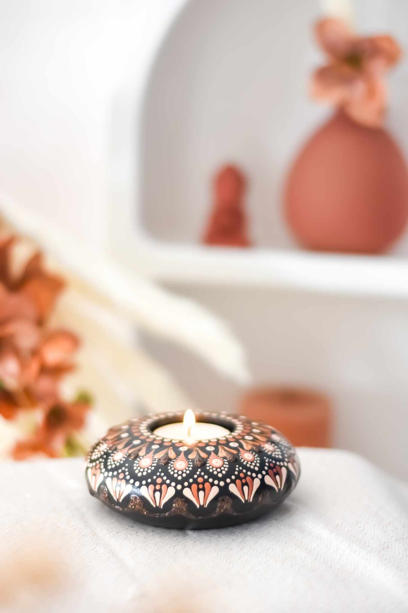 bougeoir fait main avec mandala rose et doré sur fond noir contenant une bougie.