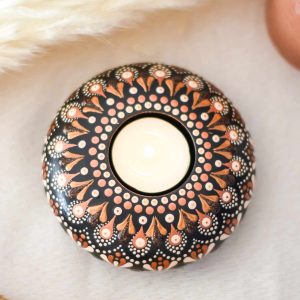 bougeoir fait main avec mandala rose et doré sur fond noir contenant une bougie.