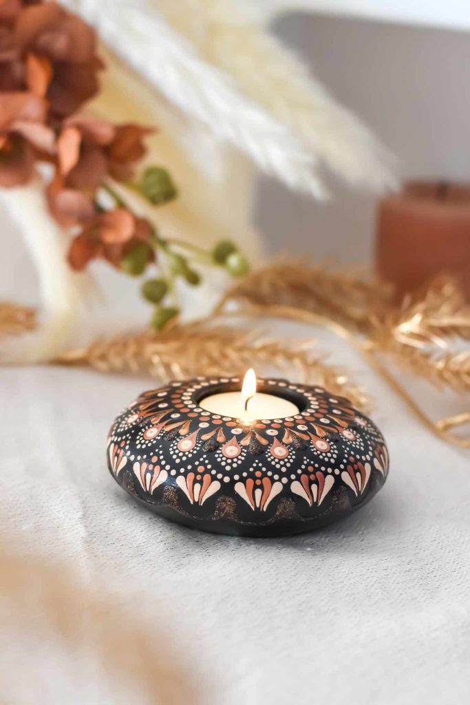 bougeoir sacré bougeoir fait main avec mandala rose et doré sur fond noir contenant une bougie.